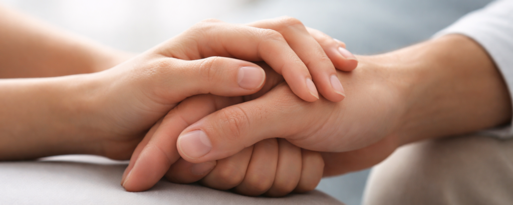 Due persone che si tengono per mano in un gesto di supporto reciproco